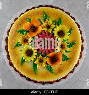 Passage tiré d'un gâteau décoré avec du fondant fleurs et saupoudré de paillettes comestibles. Banque D'Images