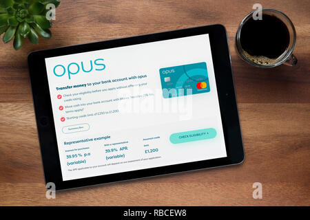 Le site web de l'Opus La carte est visible sur un iPad tablet, sur une table en bois avec une machine à expresso et d'une plante (usage éditorial uniquement). Banque D'Images