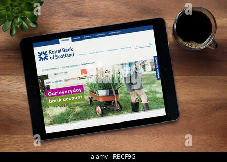 Le site web de la Banque Royale d'Écosse est vu sur un iPad tablet, sur une table en bois avec une machine à expresso et d'une plante (rédaction uniquement). Banque D'Images