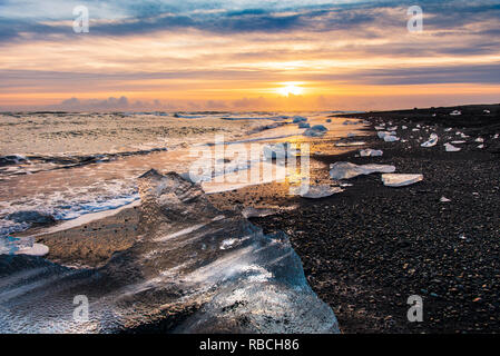 Éclaboussures des vagues sur la plage du Diamant en Islande pendant le coucher du soleil Banque D'Images