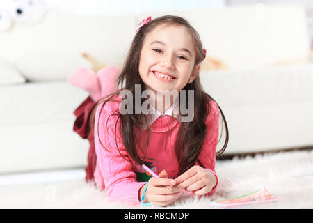 Close up.petite fille dessine allongée par terre dans la chambre Banque D'Images