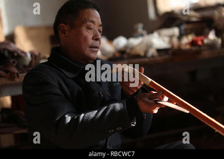 Linyi, Chine, la province de Shandong. 8 janvier, 2019. Zhenbao Gao villageois vérifie le pôle d'Erhu, un Chinois deux cordes instrument courbé à Ao Village de Miaoshan Ville de Linyi City, Shandong Province de Chine orientale, le 8 janvier 2019. Ao est célèbre pour son temps-honoré d'Erhu fait main, avec plus de 90 ménages dédié à elle dans le village. Credit : Zhang Chunlei/Xinhua/Alamy Live News Banque D'Images