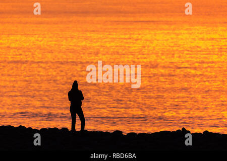 Aberystwyth, Ceredigion, pays de Galles, Royaume-Uni. 09Th Jan, 2019. Météo France : personnes ont apprécié un coucher de soleil sur la côte ouest d'Aberystwyth, à la fin d'un jour froid froid. Crédit : Ian Jones/Alamy Live News Banque D'Images