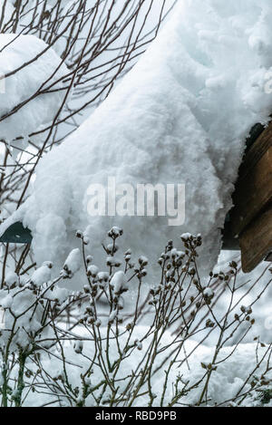 Transport de la neige sur le toit, d'après deux jours de neige. D'épaisses couches accroché sur le toit de maison. Allemagne Bavière Banque D'Images