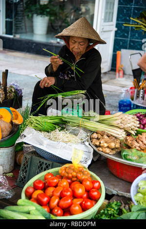 Vendeur de légumes vietnamien dans un marché de rue à Saigon, Vietnam. Banque D'Images