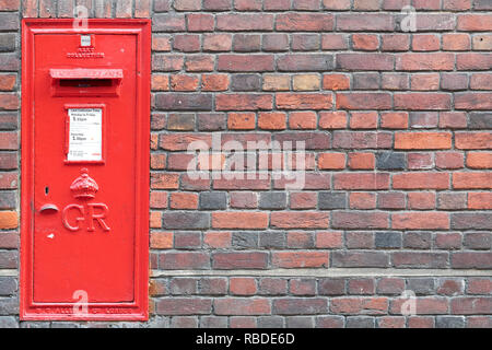 Red post box encastrée dans un mur de brique extérieur du Sidney Sussex College, Université de Cambridge, Angleterre. Banque D'Images