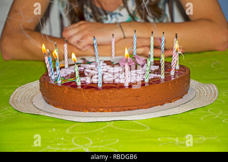 Jeune fille est de souffler les bougies sur son gâteau d'anniversaire Banque D'Images