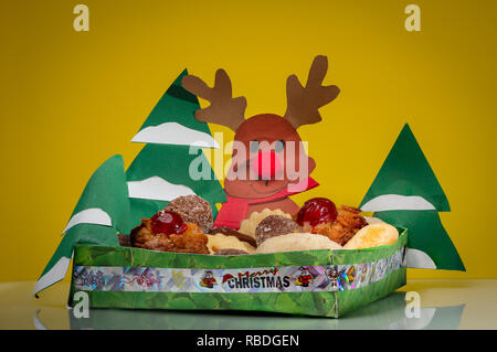 Un petit bol en papier avec divers biscuits de Noël, les arbres et les rennes Banque D'Images