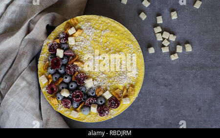 Berry et végétalien premières mango cheesecake sans gluten sur un fond de bois blanc, la noix de coco Banque D'Images
