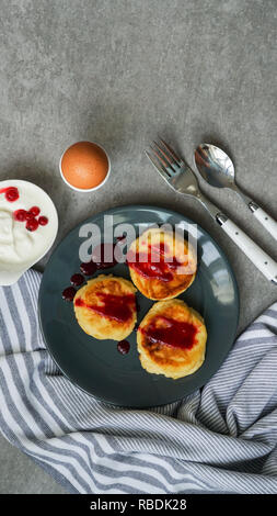 Crêpes au fromage cottage, délicieux petit-déjeuner sain, vue de dessus, l'arrière-plan en pierre grise Banque D'Images