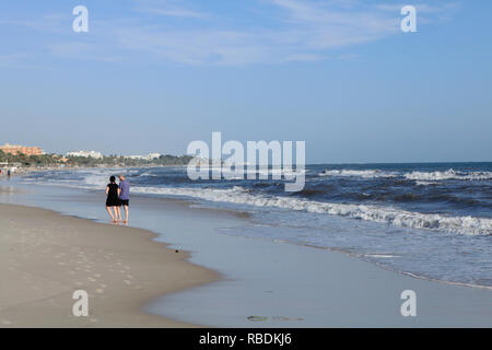 Un couple en train de marcher sur la plage de sable de Sousse. Banque D'Images