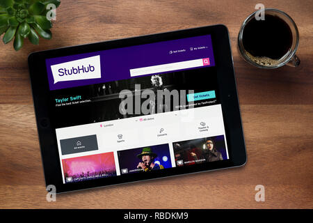 Le site internet de StubHub est vu sur un iPad tablet, sur une table en bois avec une machine à expresso et d'une plante (usage éditorial uniquement). Banque D'Images