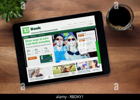 Le site internet de la Banque TD est vu sur un iPad tablet, sur une table en bois avec une machine à expresso et d'une plante (usage éditorial uniquement). Banque D'Images
