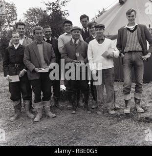 1965, historique, palmarès, un groupe d'agriculteurs dans un concours de labour se tenir ensemble pour une photo après l'événement, des bottes d'être à l'ordre du jour ! Angleterre, Royaume-Uni. Banque D'Images