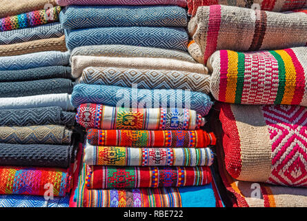 Une pile de laine Alpaga traditionnelles textiles Andes sur un stand dans le marché du dimanche de Pise près de Cusco, Pérou. Banque D'Images