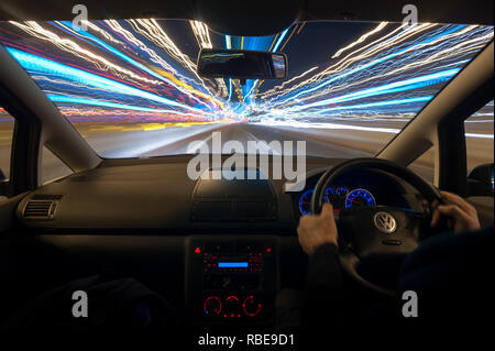 La nuit de la circulation sur les sentiers d'autoroute avec phares et en légèreté sur le plomb jusqu'à Dartford crossing tunnel avec toit de panneaux routiers Banque D'Images