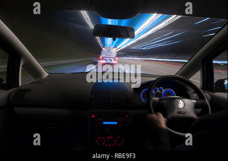 La nuit de la circulation sur les sentiers d'autoroute avec phares et en légèreté sur M20 camion-citerne de carburant bloqué derrière Banque D'Images