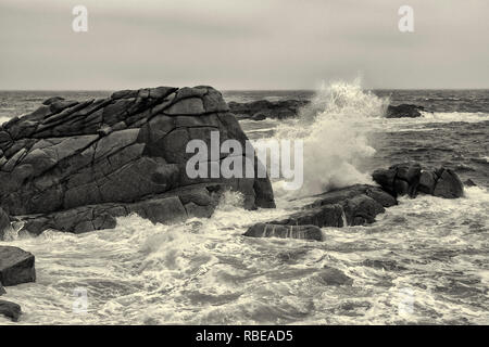 Les ondes de tempête pause sur Terre-neuve Point, St Mary's, Îles Scilly, au Royaume-Uni. Version noir et blanc Banque D'Images