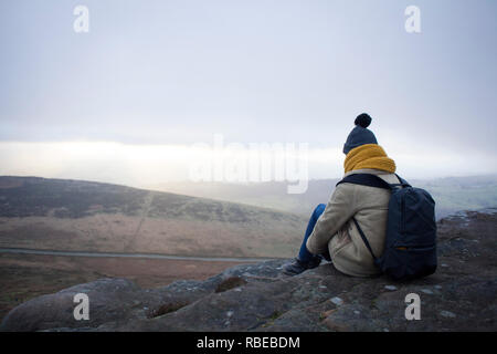 Jeune femme prend une pause pendant une randonnée jusqu'Stanage Edge, Derbyshire, Angleterre, Peak District Banque D'Images