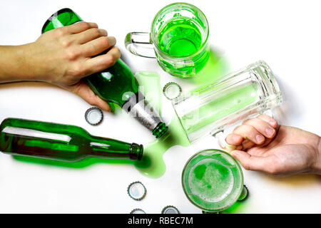 St Patrick day after party concept. Verres et bouteilles de bière verte sur tableau blanc sale avec des bouchons de bière Banque D'Images