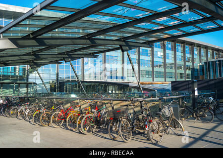 Parking vélos par le bâtiment de l'aéroport Kastrup sous couverture en verre en soirée sunshine, Copenhague, Danemark Banque D'Images