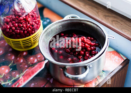 La préparation des cerises pour faire un gâteau. Les délicieuses cerises biologiques sur la table. Les cerises dénoyautées dans une casserole avec de l'eau Banque D'Images