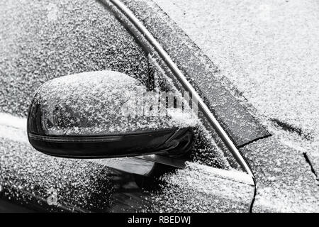 Miroir de voiture noire couverte de gel et de neige fraîche en saison d'hiver froid Banque D'Images