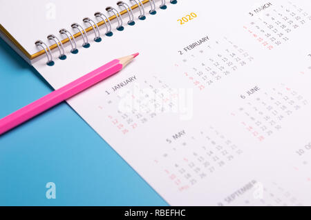 Crayon rouge et calendrier sur fond bleu Banque D'Images