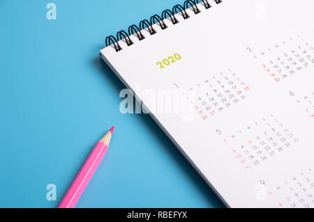 Crayon rouge et calendrier sur fond bleu Banque D'Images