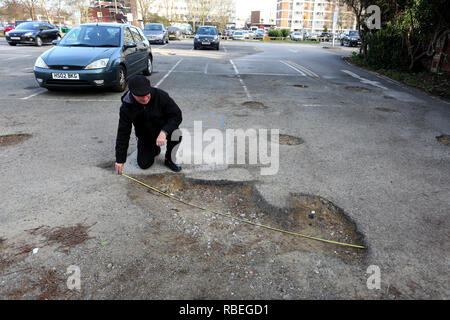 La mesure de l'homme grand pot-trous dans un parking public à Bognor Regis, West Sussex, UK. Banque D'Images