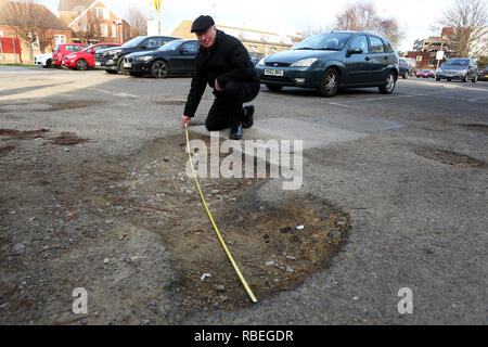 La mesure de l'homme grand pot-trous dans un parking public à Bognor Regis, West Sussex, UK. Banque D'Images