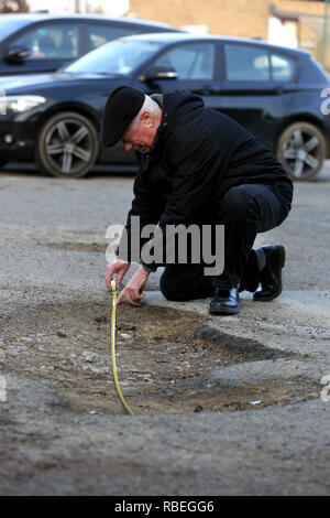 La mesure de l'homme grand pot-trous dans un parking public à Bognor Regis, West Sussex, UK. Banque D'Images