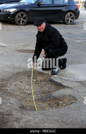 La mesure de l'homme grand pot-trous dans un parking public à Bognor Regis, West Sussex, UK. Banque D'Images