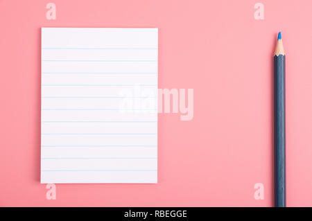 Memo stiker blanc et crayon de couleur sur fond rouge Banque D'Images