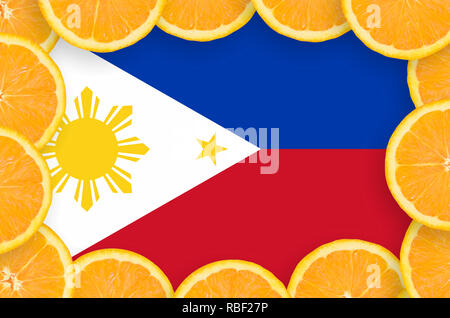Drapeau Philippines dans le cadre de tranches d'agrumes orange. Concept de croissance et de l'importation et l'exportation des agrumes Banque D'Images