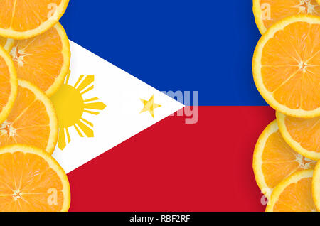 Philippines drapeau dans cadre vertical des tranches d'agrumes orange. Concept de croissance et de l'importation et l'exportation des agrumes Banque D'Images
