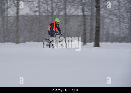 Munich Riem, Deutschland. 10 janvier, 2019. Le chaos de la neige sur les rues de Bavière - probablement celle qui arrive à son lieu de travail en vélo, comme ce cycliste avec gilet signal de conduire sur la neige, neige-couvertes piste cyclable. Neige continue sur 10.01.2019, fournir pour la neige le chaos, le chaos de la circulation, d'hiver en Bavière. Utilisation dans le monde entier | Credit : dpa/Alamy Live News/Alamy Live News Banque D'Images