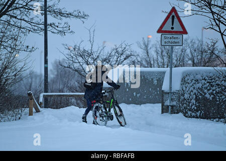 Munich Riem, Deutschland. 10 janvier, 2019. Le chaos de la neige sur les rues de la Bavière - ce cycliste pousse son vélo sur un couvert de neige, piste cyclable couverte de neige. Neige continue sur 10.01.2019, fournir pour la neige le chaos, le chaos de la circulation, d'hiver en Bavière. Utilisation dans le monde entier | Credit : dpa/Alamy Live News/Alamy Live News Banque D'Images