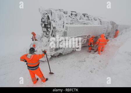 10 janvier 2019, la Saxe-Anhalt, Schierke : employés de la chemin de fer à voie étroite du Harz HSB travaillent dur sur le Brocken pour récupérer un train qui n'a pas été déblayée dans depuis mardi. Il n'a pas encore été possible de libérer la locomotive avec un chariot de les masses de neige. Photo : Matthias Bein/dpa-Zentralbild/ZB Banque D'Images