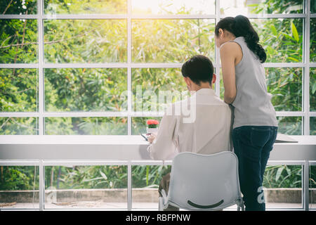Asian Business couple travaillant ensemble sur le démarrage du projet au bureau moderne. Senior business woman suggestion nouveau travailleur man at desk in office. Banque D'Images