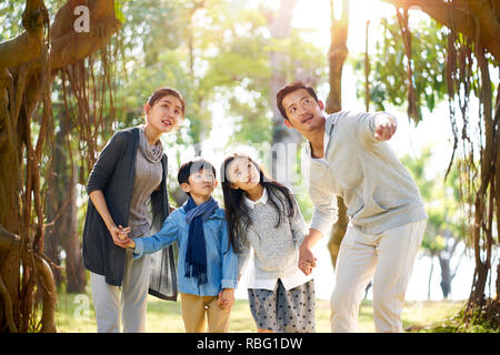 La famille asiatique avec deux enfants s'amusant à explorer les bois dans un parc. Banque D'Images