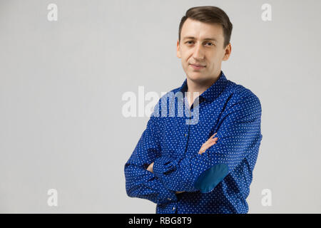 Portrait d'un homme en vêtements d'affaires avec les mains pliées sur un fond blanc Banque D'Images