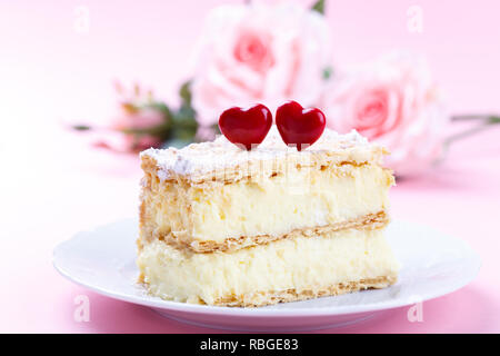 Mille feuille français avec crème vanille gâteau décoré avec des coeurs sur fond rose pour la Saint-Valentin Banque D'Images