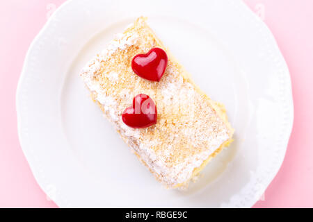 Mille feuille français avec crème vanille gâteau décoré avec des coeurs sur fond rose pour la Saint-Valentin Banque D'Images