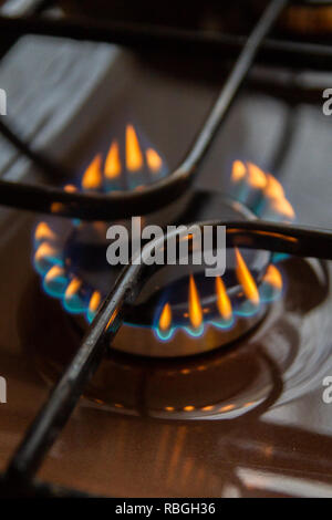 Cuisinière à gaz de combustion avec l'orange et le bleu le feu sur elle Banque D'Images