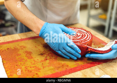 Chef pâtissier dans la préparation de gâteau à la meringue et gants de desserts. Concept de production de confiseries Banque D'Images