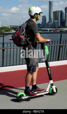 Une personne faisant la Chaux-S scooter électrique à travers la Bonne Volonté Bridge, Brisbane, Queensland, Australie Banque D'Images