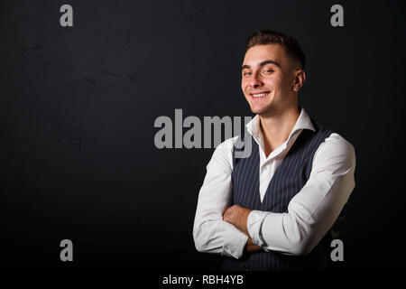 Portrait of young man wearing white shirt debout sur le fond gris et de rire Banque D'Images