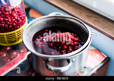 Les cerises dénoyautées dans une casserole avec de l'eau. Les délicieuses cerises biologiques sur la table. La préparation des cerises pour faire un gâteau Banque D'Images