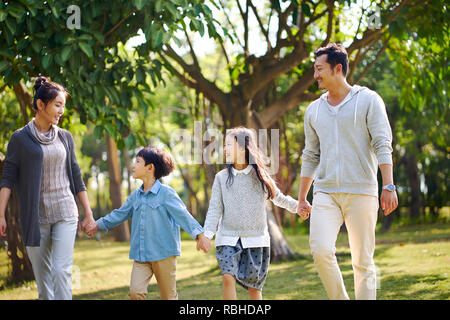 Famille avec deux enfants asiatiques dans la marche heureux et souriants. Banque D'Images